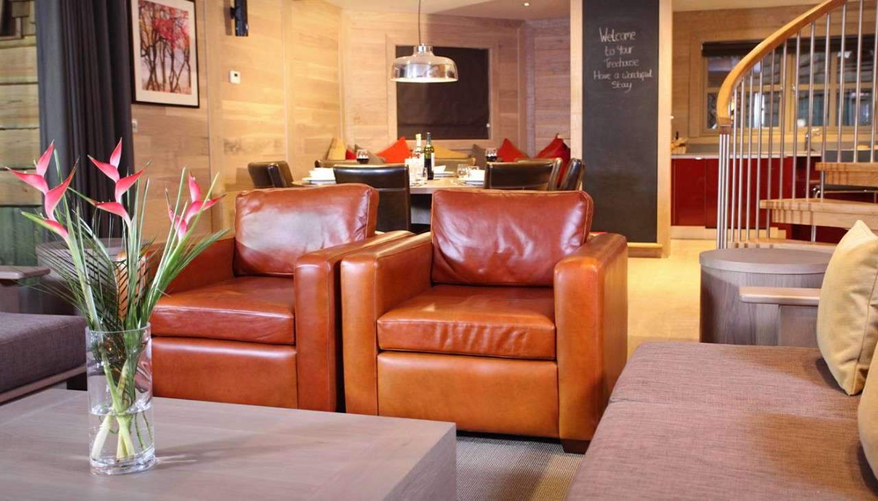 Two brown leather armchairs side by side with a sofa.
