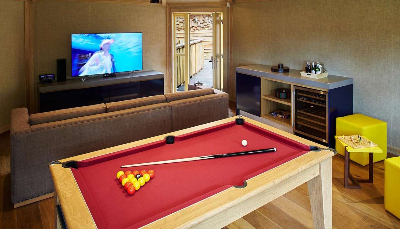 Treehouse game den with a pool table and TV.