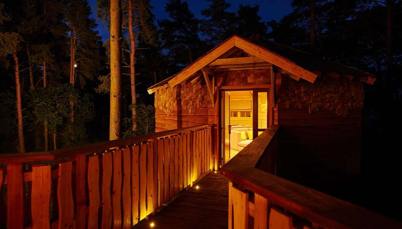 The entrance way to a Treehouse lit up at night