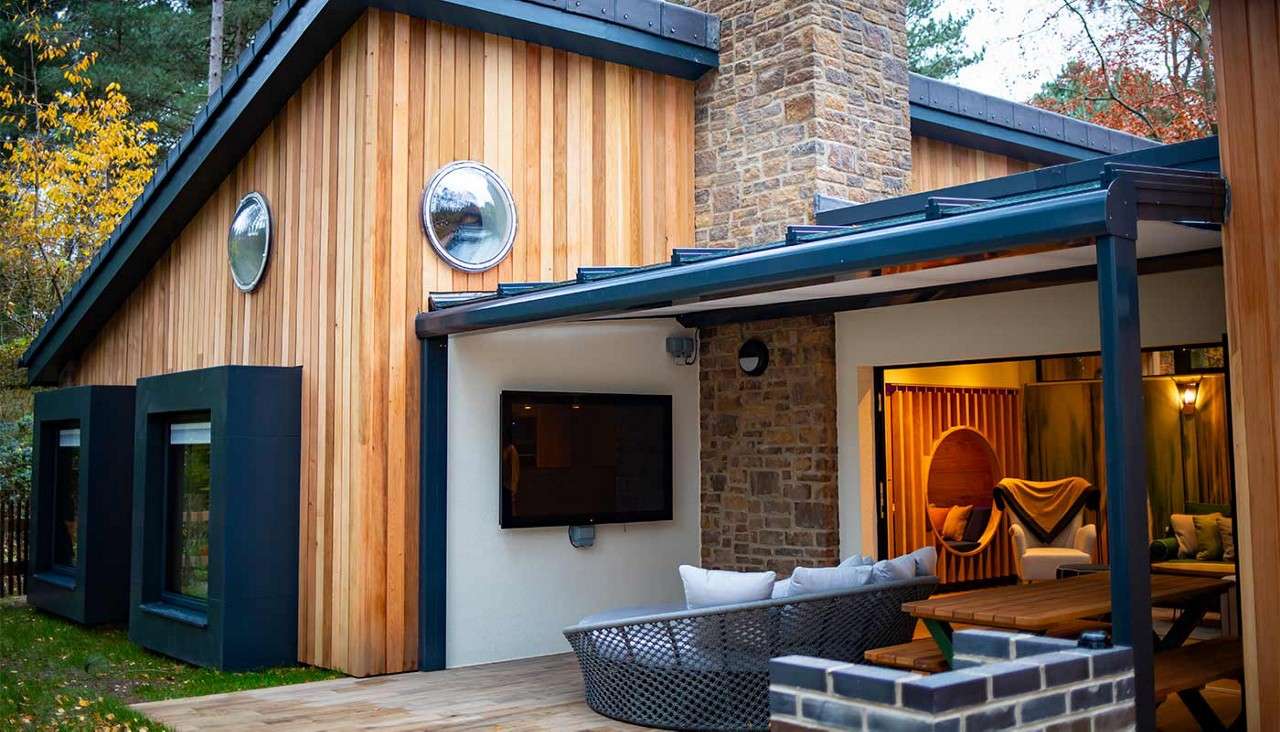 Open plan lounge with glass covered patio and outdoor TV.