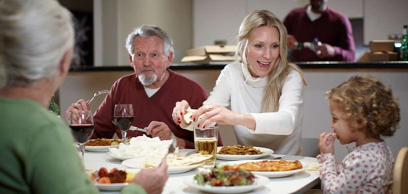 A family with a small child eating at the dinner table