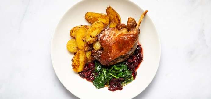 Duck Confit served with sautée potatoes, wilted spinach and morello cherry & thyme jus.