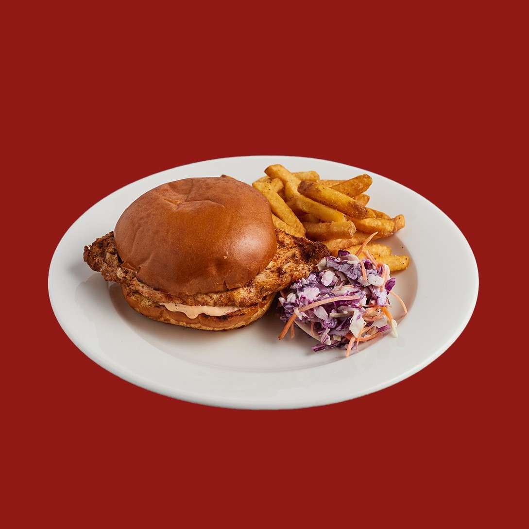 Cajun spiced grilled chicken burger in a brioche bun with fries and slaw.