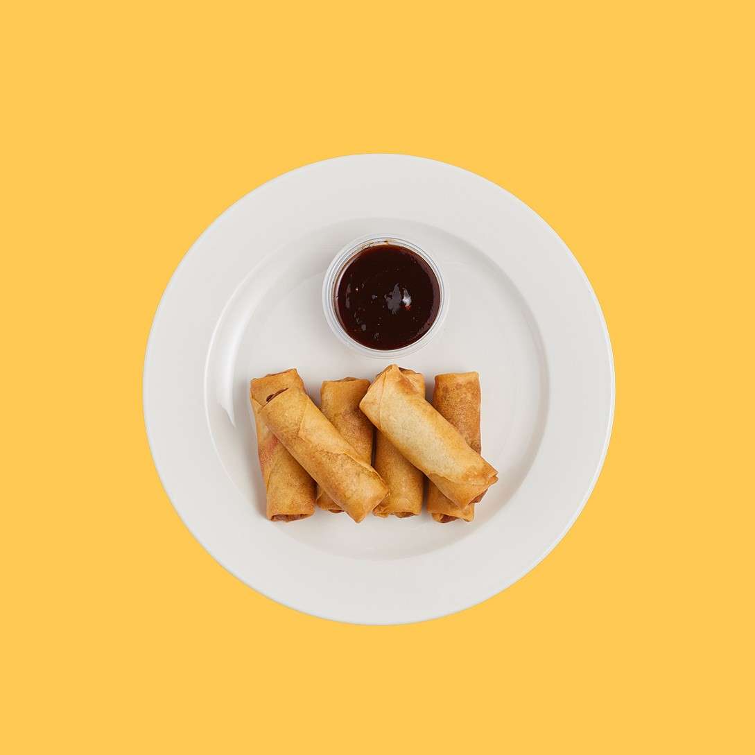 Crispy duck spring rolls served with a dipping sauce.