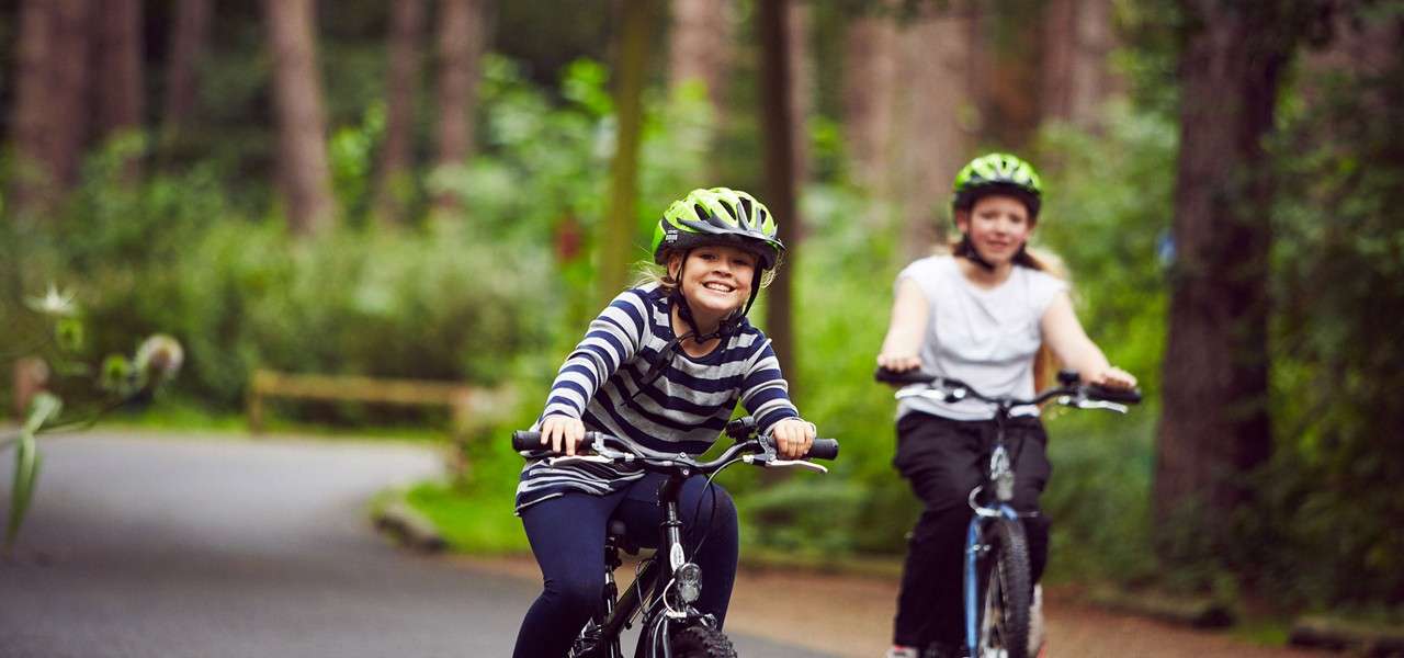 Girls cycling through forest
