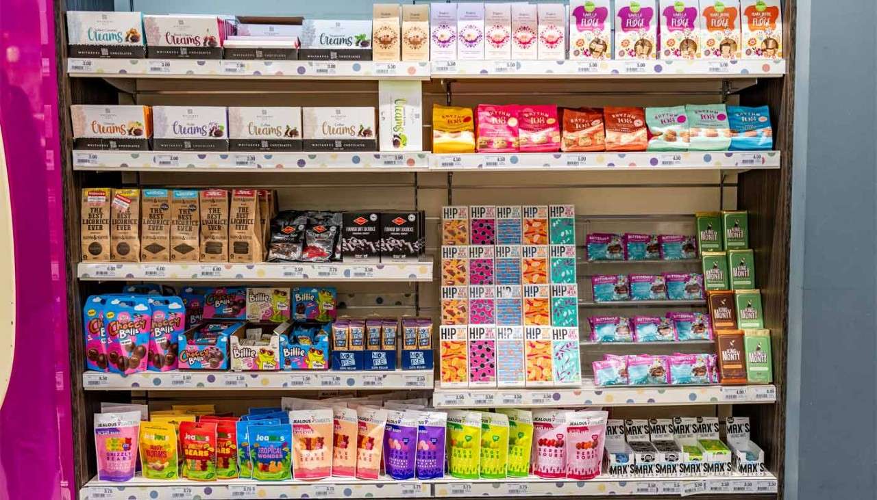 Shelves stacked with colourful sweets and chocolate packets.
