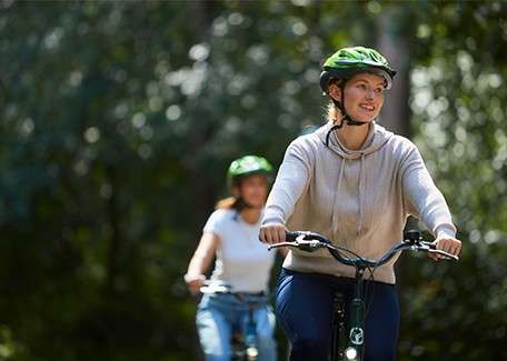 Adults cycling through the forest.