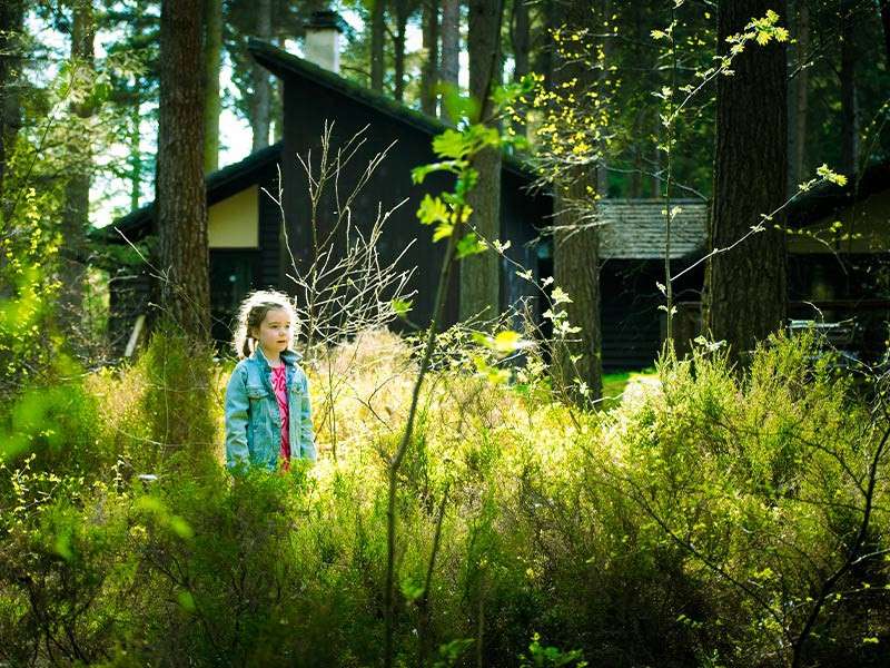 A little girl walking through long grass.