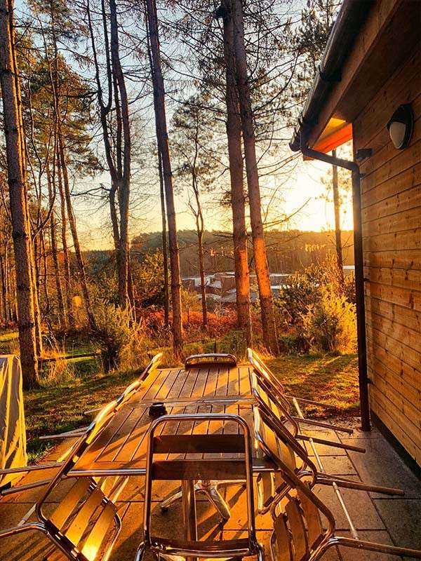 The sun rising on a patio outside a lodge.