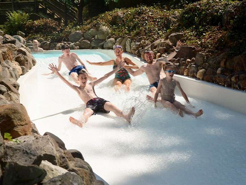 A family sliding down the rapids together.