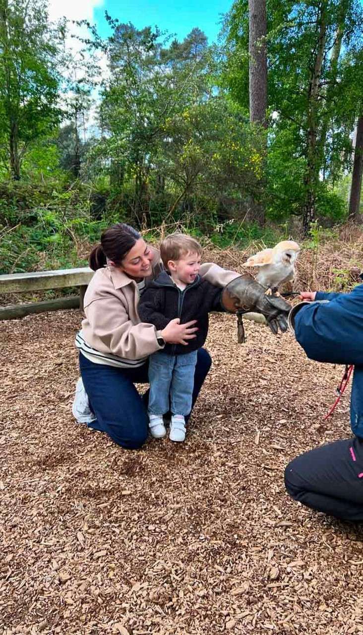 A boy holding an owl on his arm.