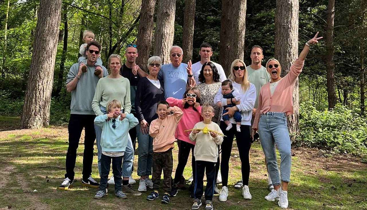 A large family all stood together pulling funny faces for a photo.