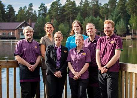 Center Parcs staff stood together for a photo in front of the lake.