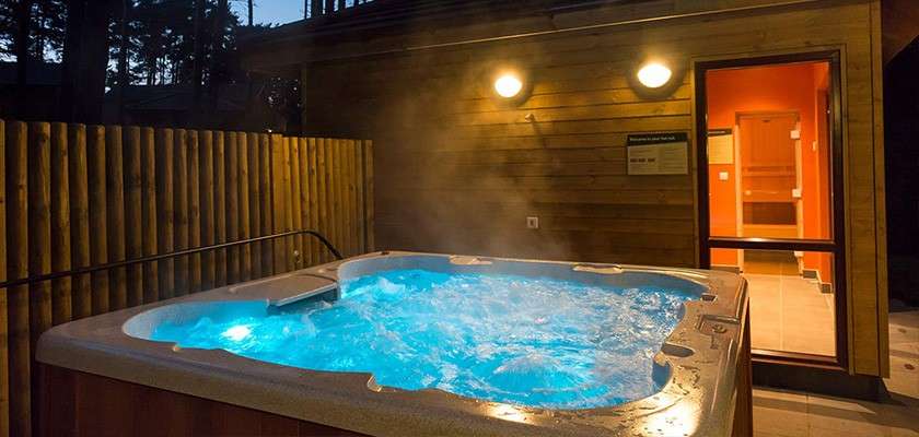 A hot tub outside a lodge at night time.