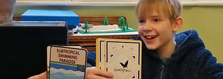 A boy holding Center Parcs branded cards.