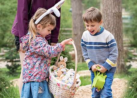 A little girl and boy doing the Easter egg discovery trail.