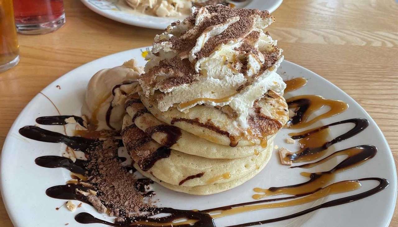 Pancakes stacked with fresh cream and chocolate sauce from the Pancake House.