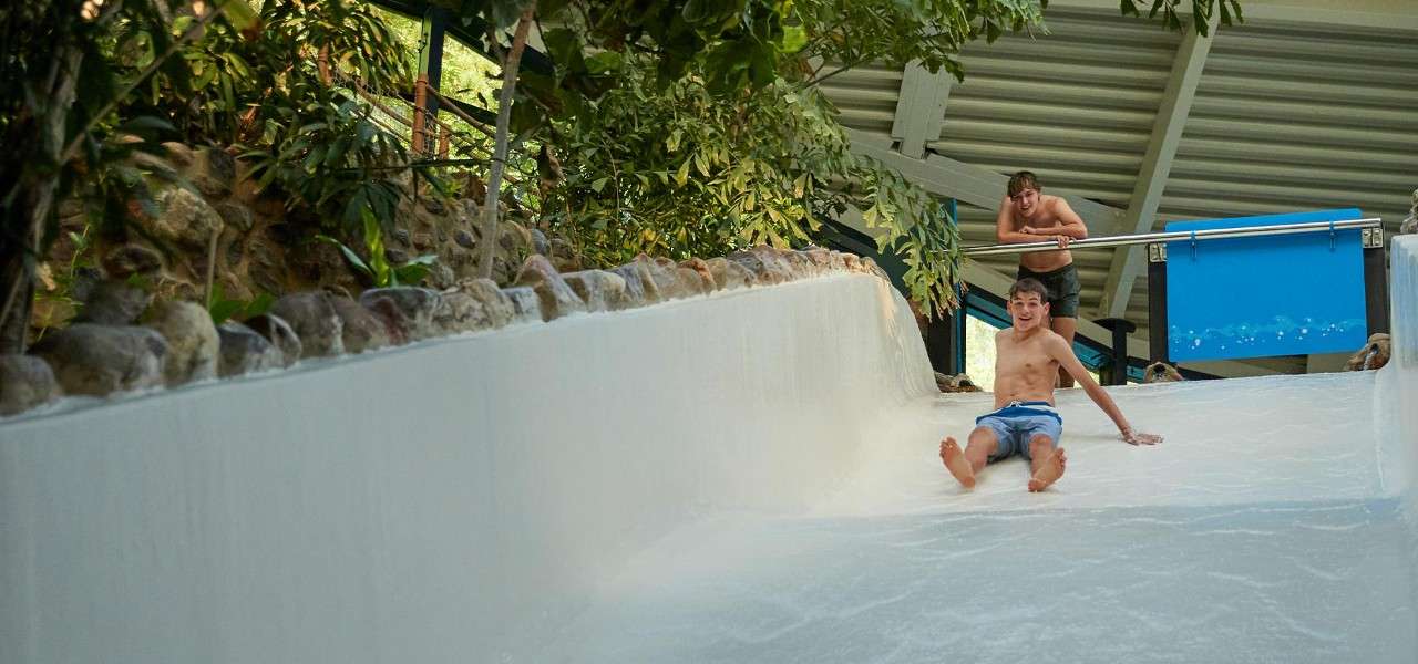Teenage boy going down a slide in the Subtropical Swimming Paradise.