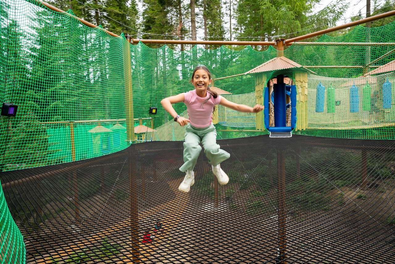Young girl jumping on suspended nets.