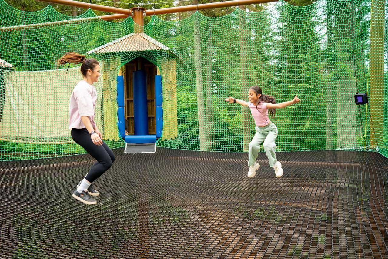 Two people jumping on suspended nets.