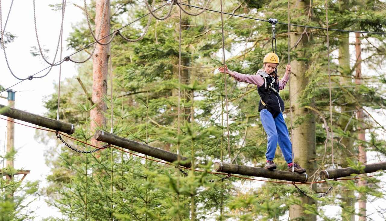 Two young people crossing a suspended bridge 