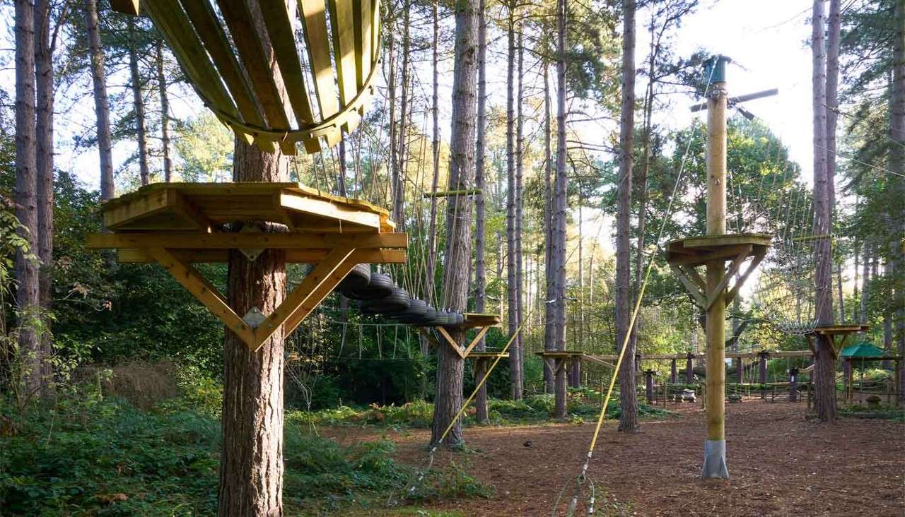 A young person walking over a suspended rope bridge