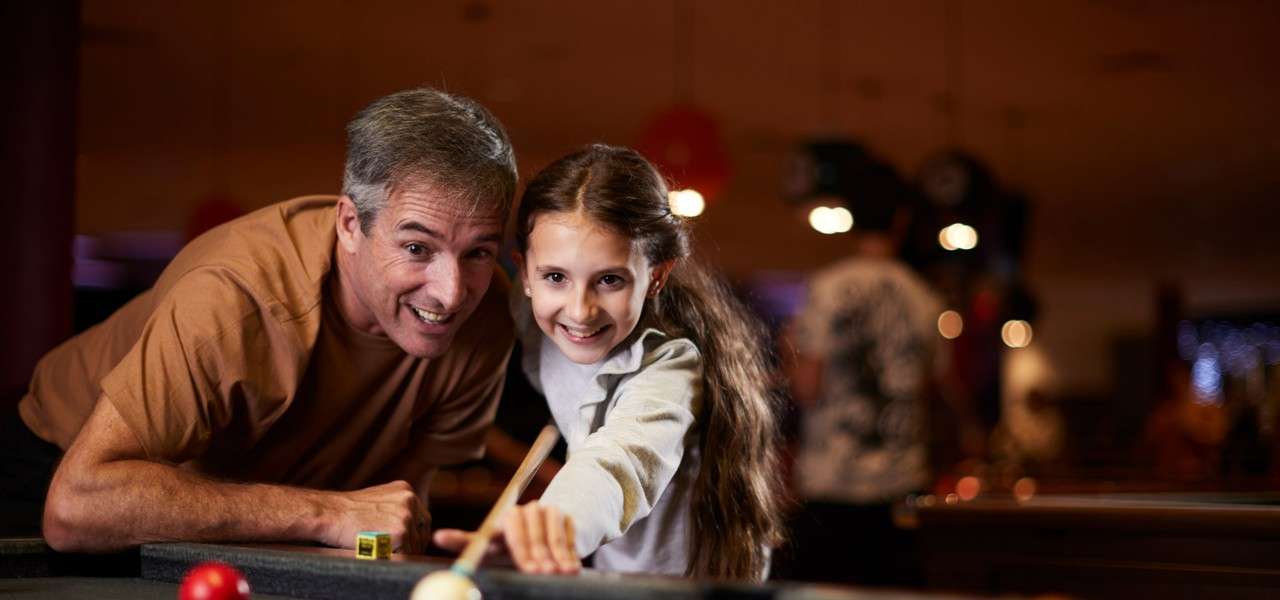 Man and child taking part in American Pool