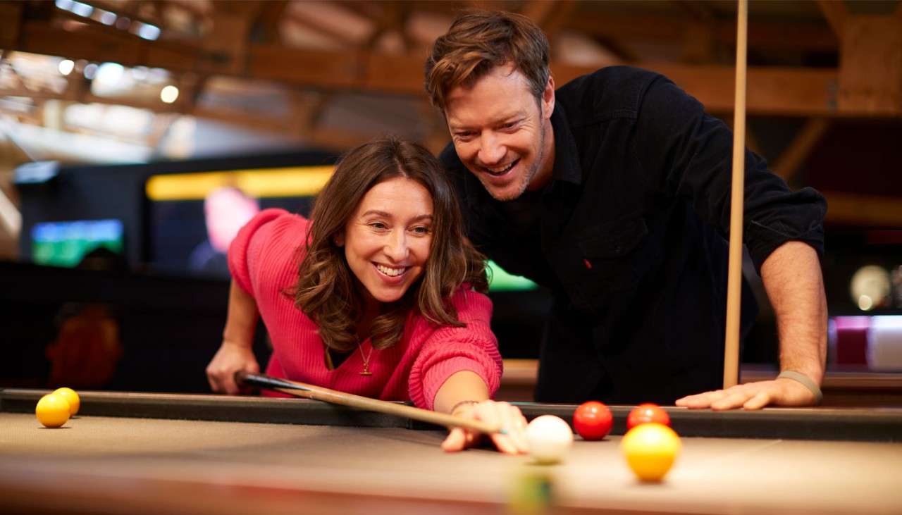 Woman and man playing pool