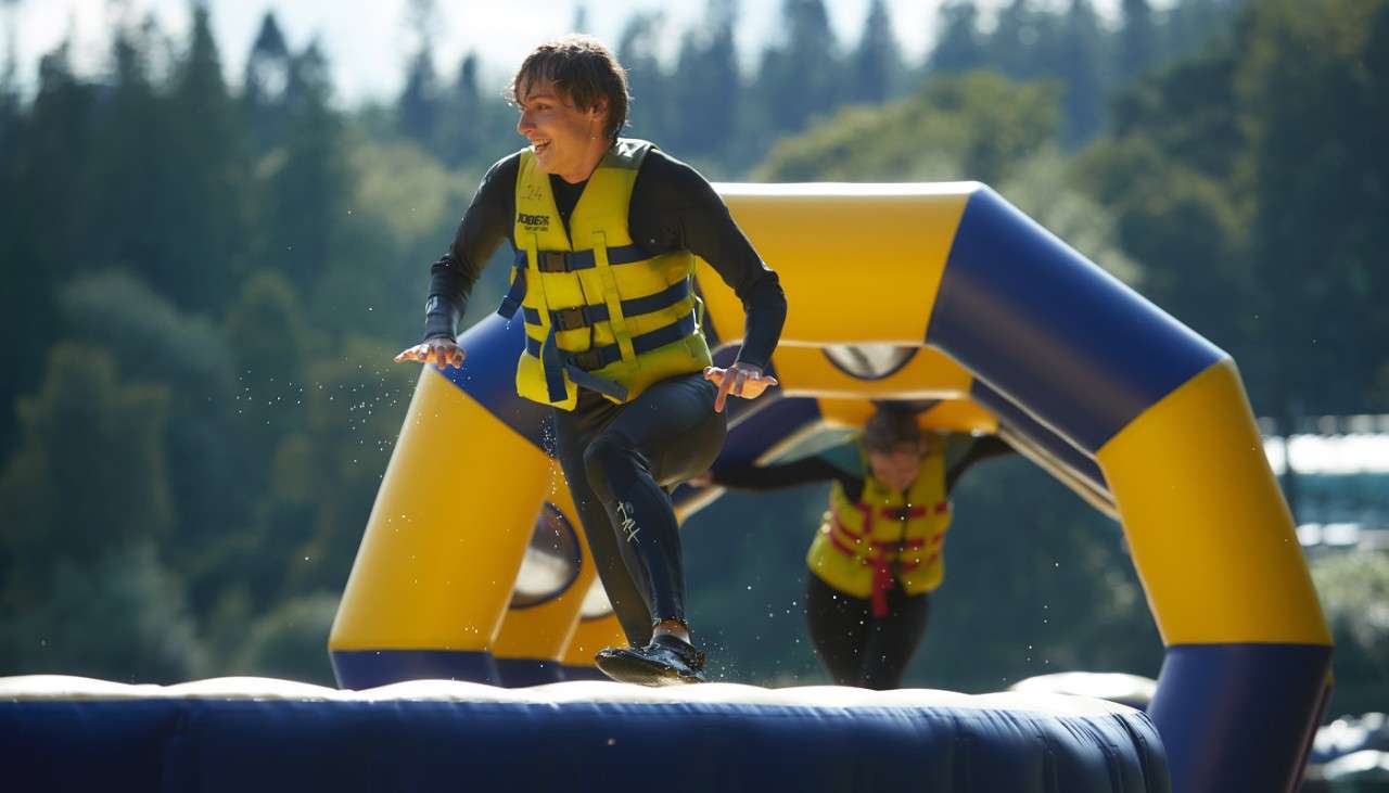Teenage boy running over an inflatable obstacle course