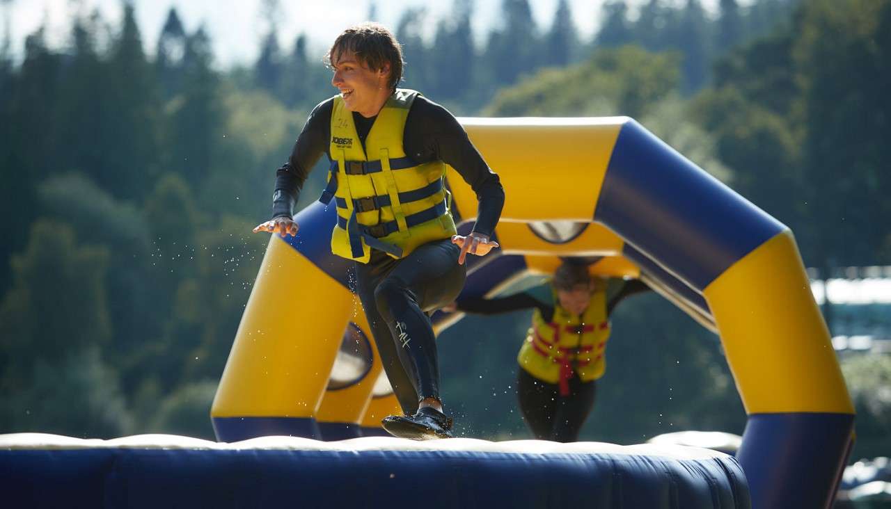 Teenage boy running over an inflatable obstacle course