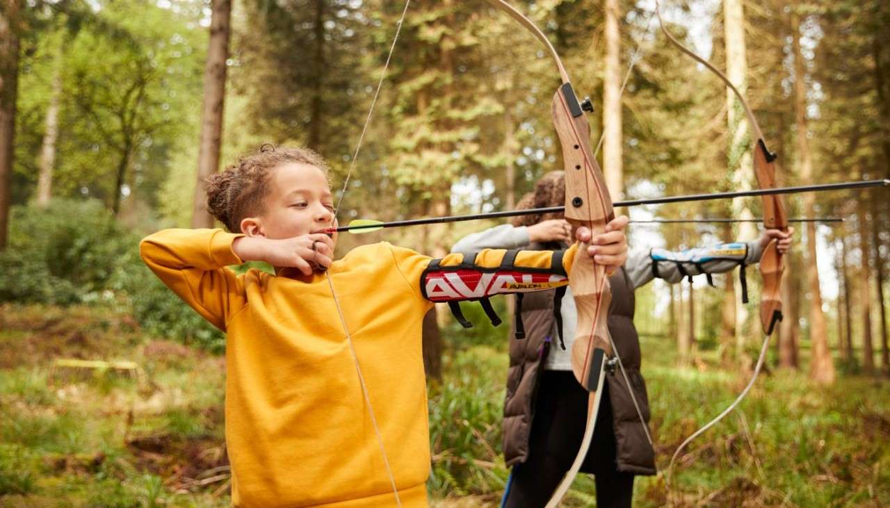 Boy aiming a bow and arrow