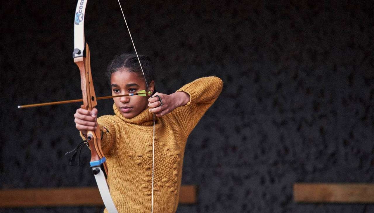 Teenage girl practicing target archery 