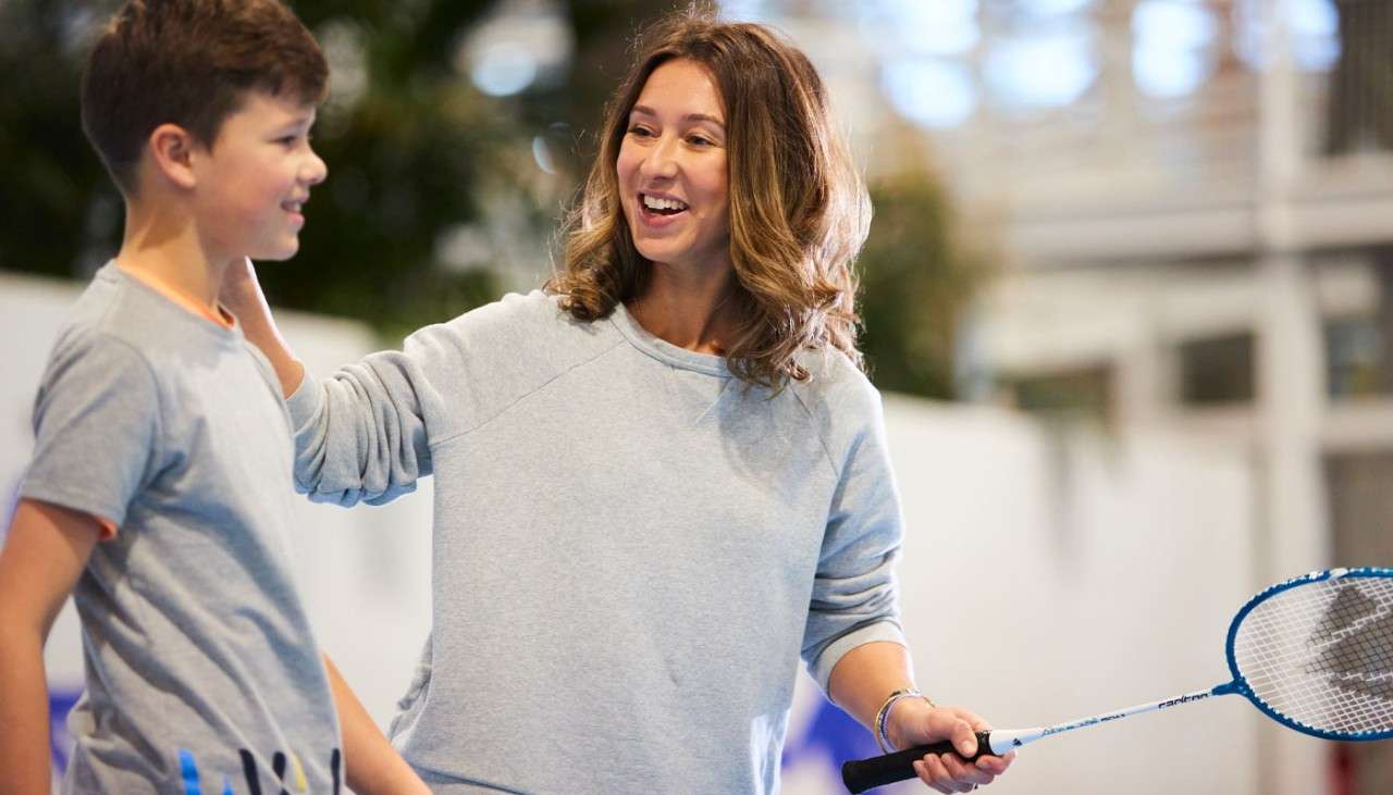 Woman and boy playing badminton