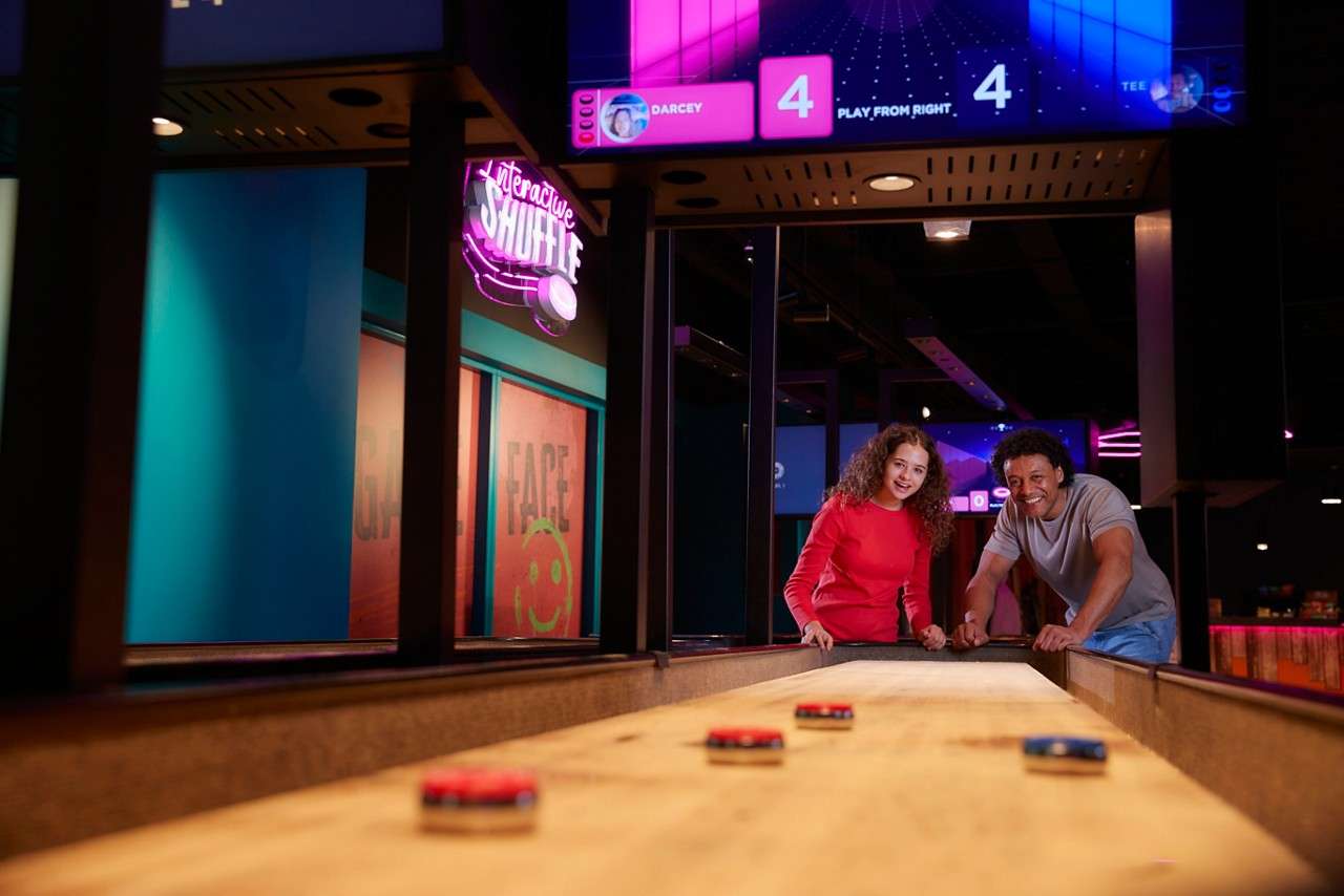Two adults laughing and smiling playing Interactive Shuffle.