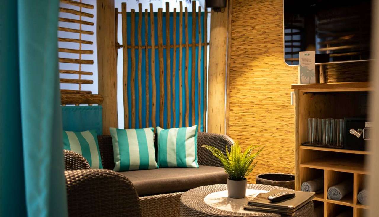 Cosy seating, fresh towels and a mounted TV inside the Exclusive Cabana Cove area.