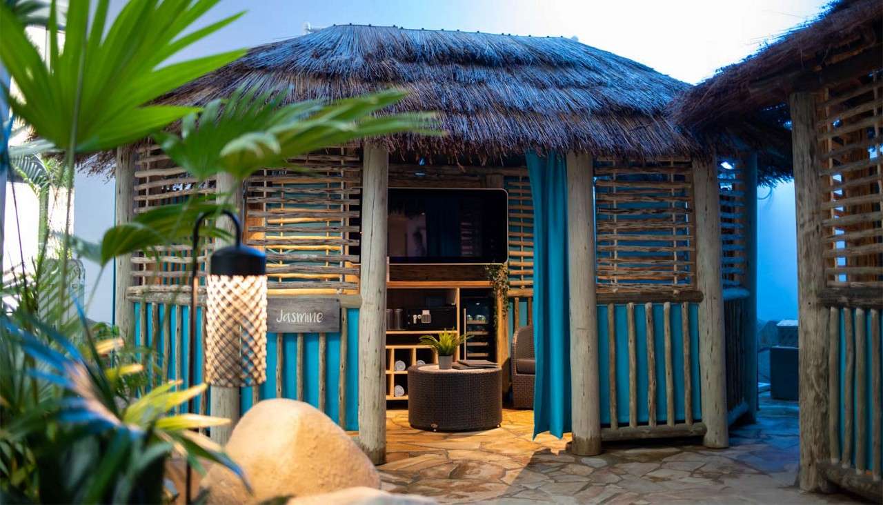 Inside the Cabana Cove with cosy seating, fresh towels and a mounted TV.
