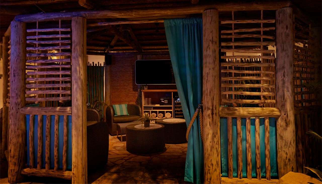 Inside the Cabana Cove with cosy seating, fresh towels and a mounted TV.