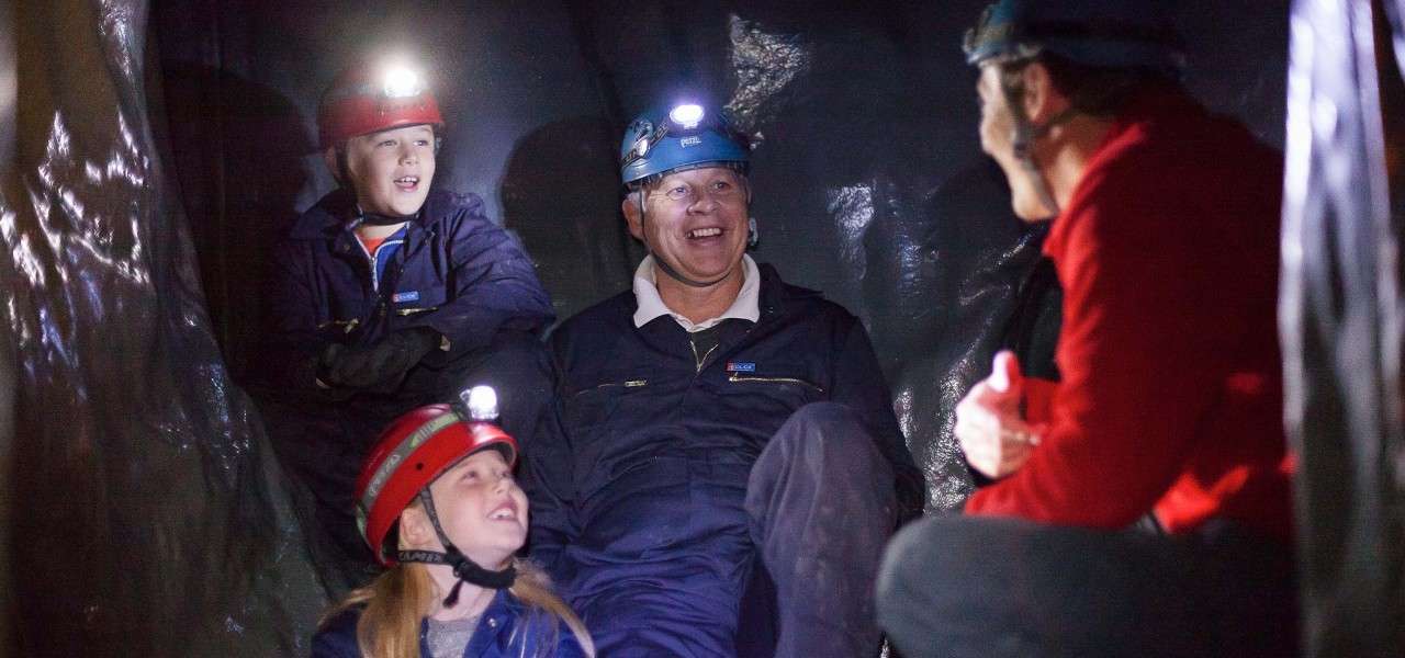 Father and two children doing the caving adventure
