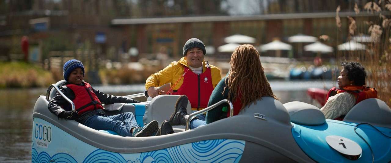 Family sat in electric boat on the lake