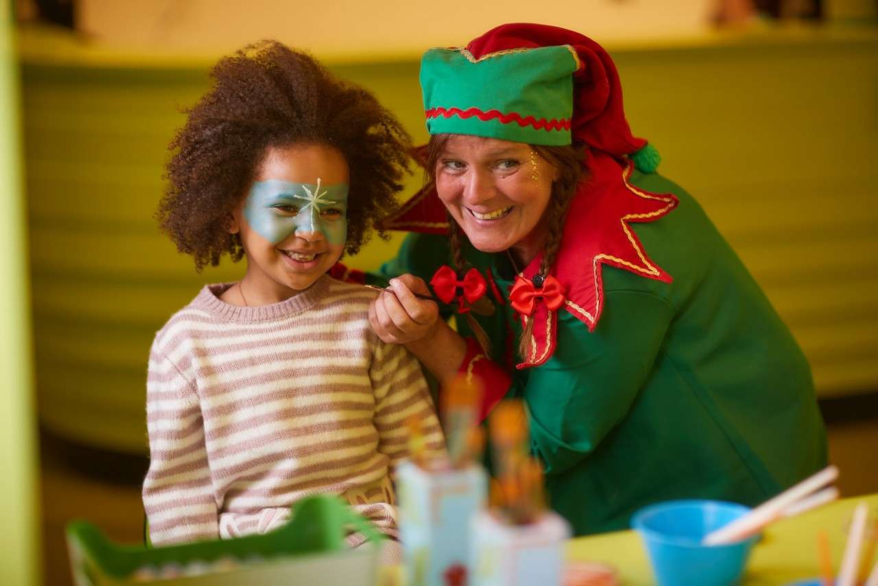Girl having her face painted by an elf.