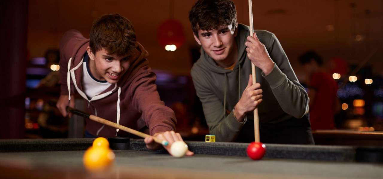 Two teenagers playing pool.