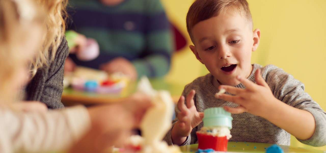 young boy decorating a cupcake