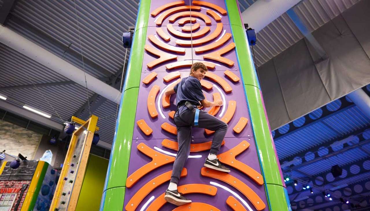 Girl scaling a climbing wall