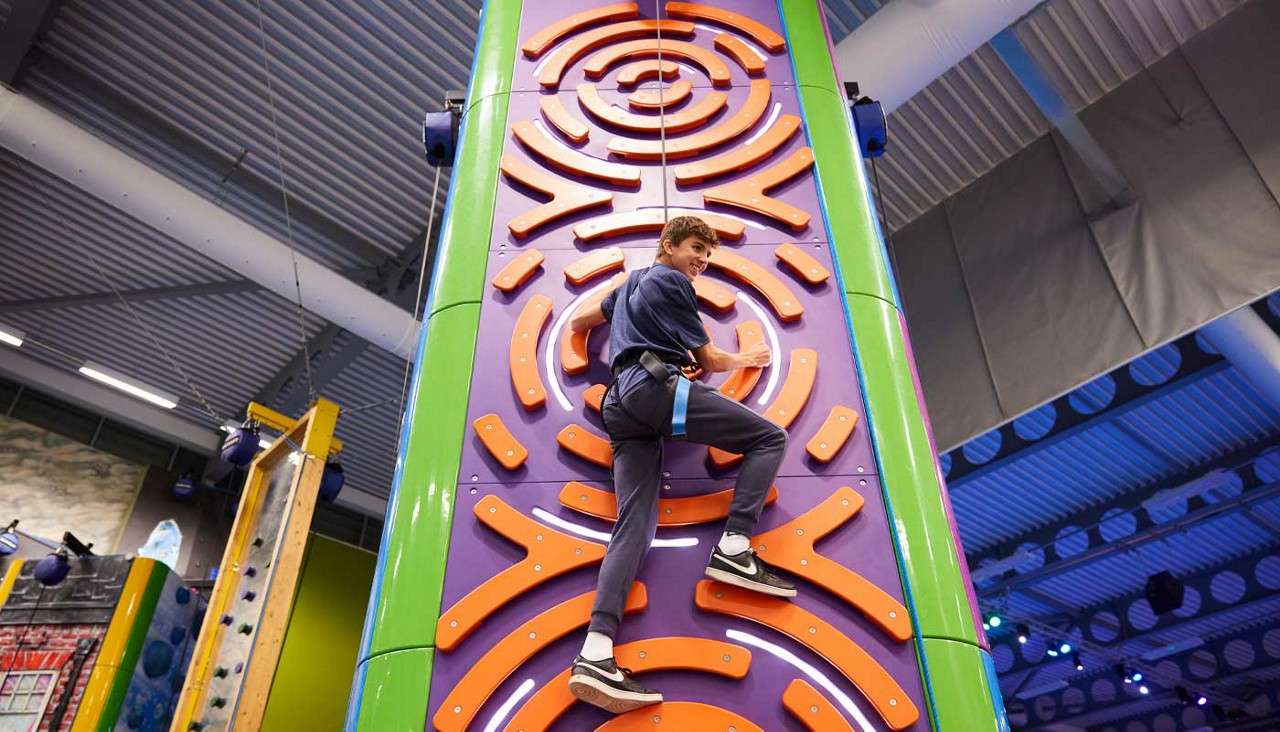 Girl scaling a climbing wall