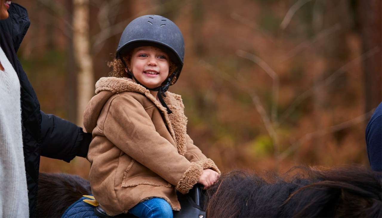 Young girl riding a pony