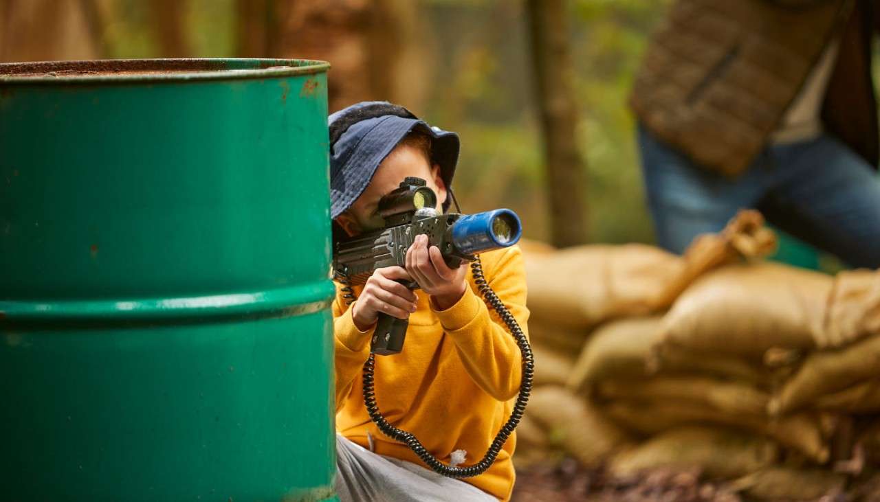 Young boy aiming a gun in Laser Combat
