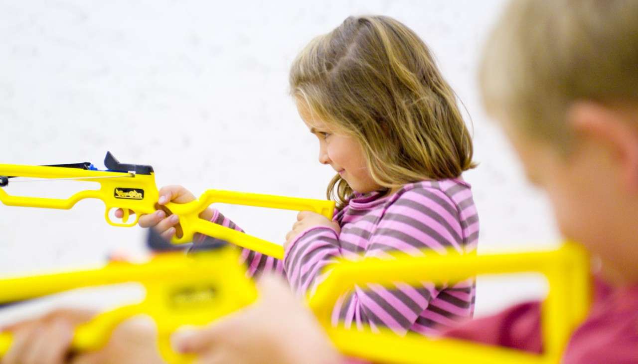 Young girl aiming a Mini Crossbow