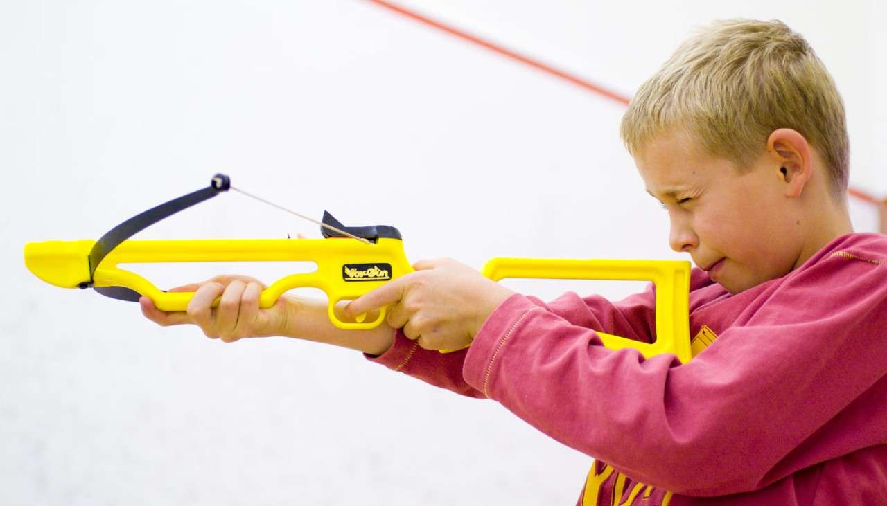 Young boy aiming a Mini Crossbow 
