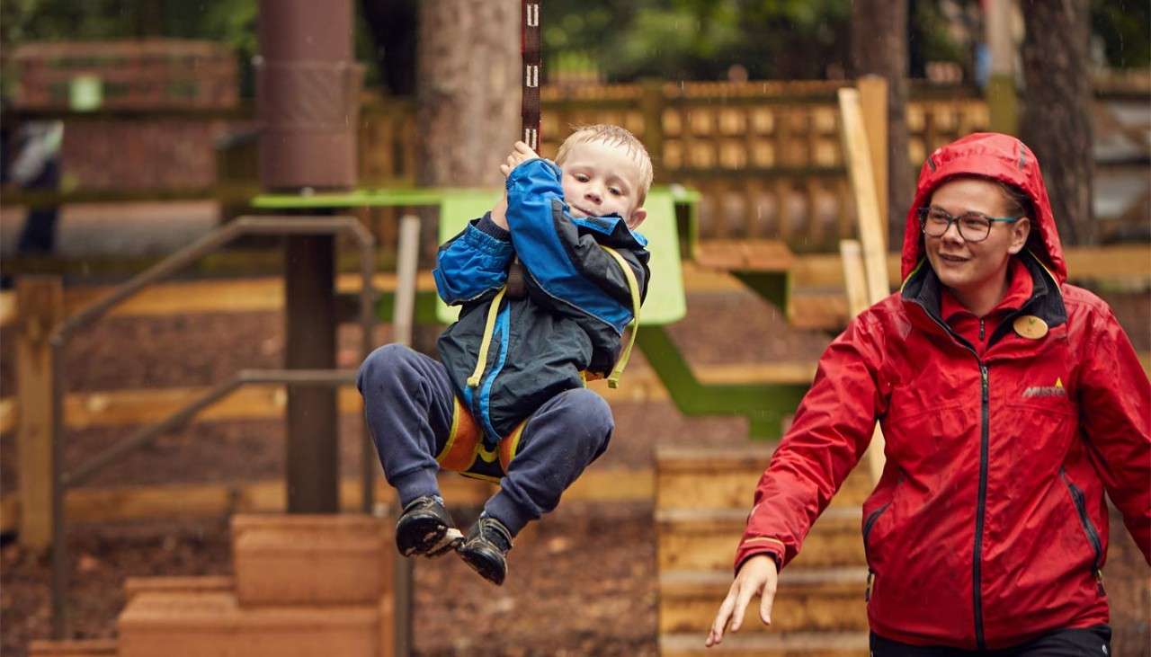 Young boy going across a zip line on the Mini Trek course