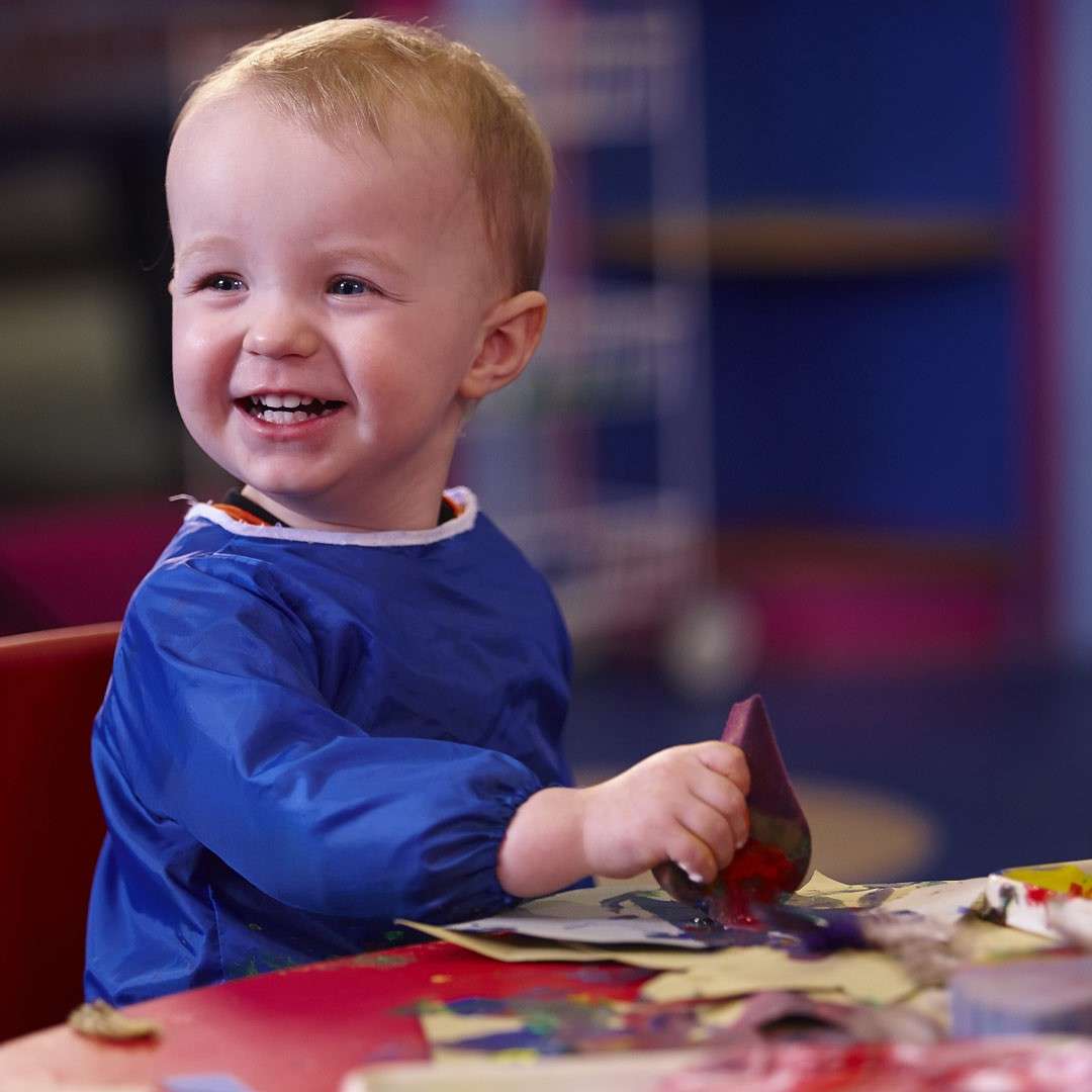 Young boy smiling whilst getting messy